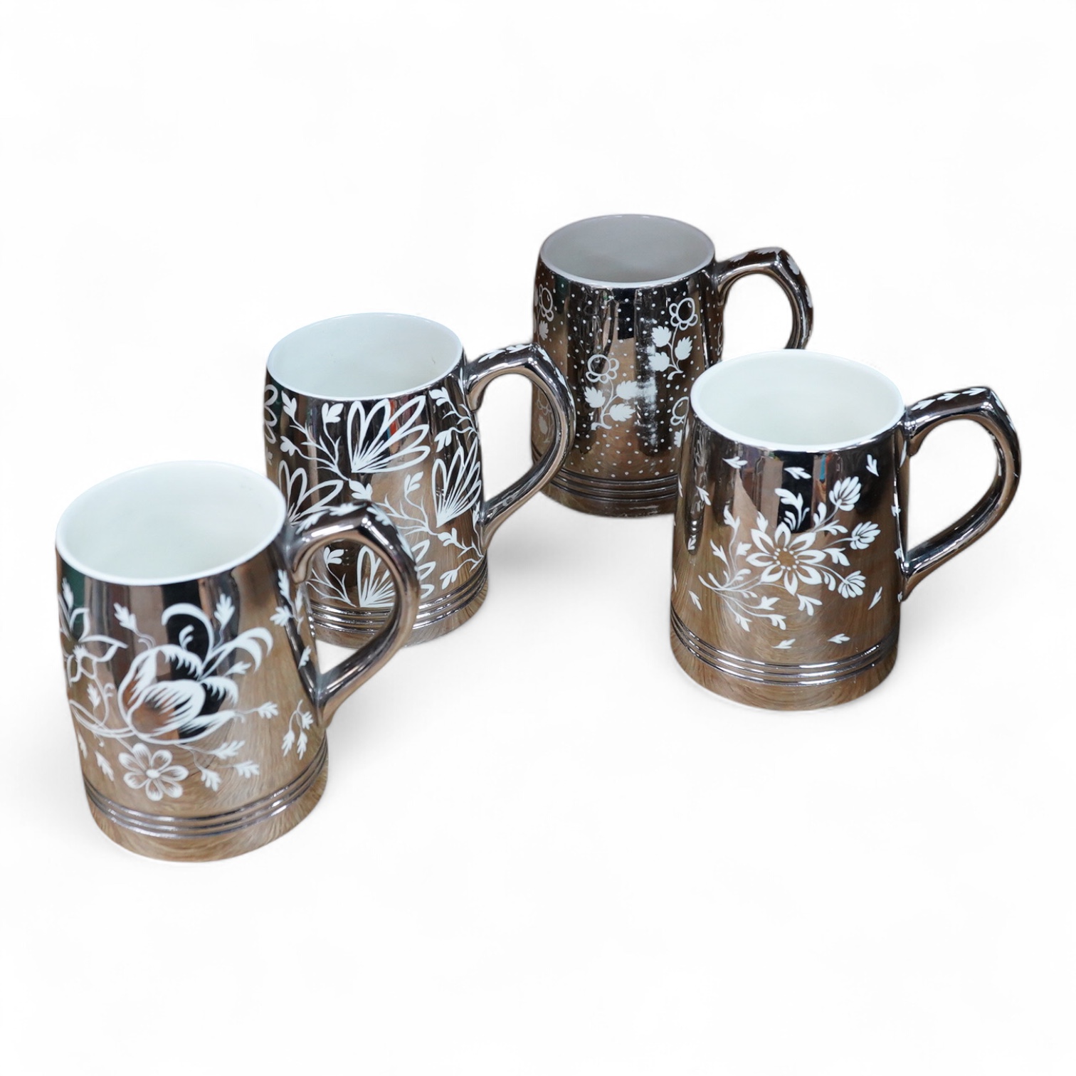Keith Murray for Wedgwood, a set of four silvered mugs, decorated by Millicent Taplin, largest 10cm high